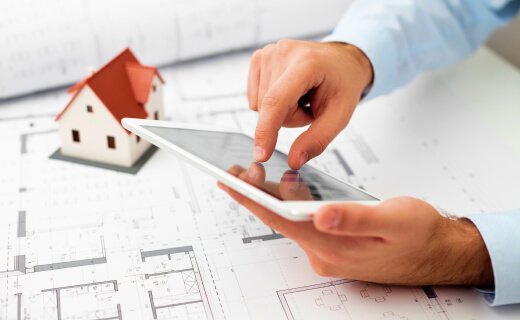 Man using tablet over blueprints